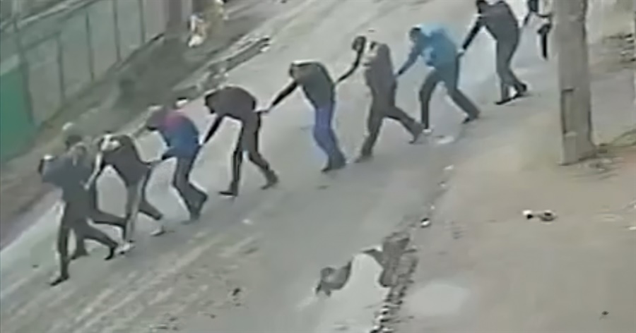 Скріншот з камери спостереження, де видно, як російські солдати ведуть українських добровольців під дулами автомата. Кадри, що облетіли світ