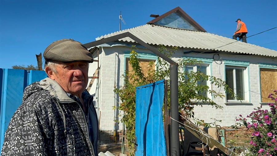 Володимир біля будинку, в якому волонтери латають дах