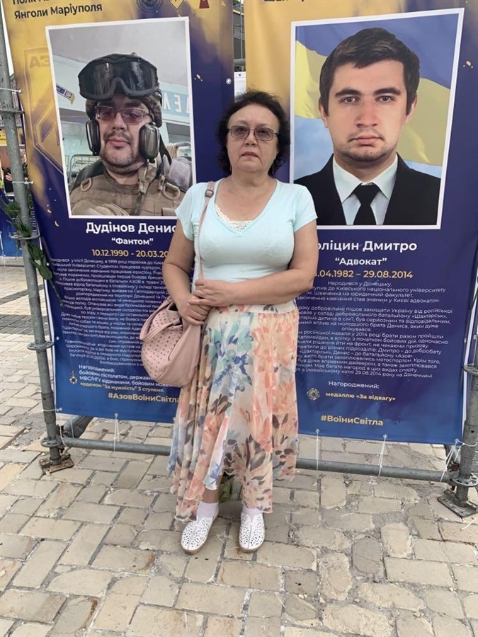Галина Голіцина біля меморіальних стендів своїх синів 